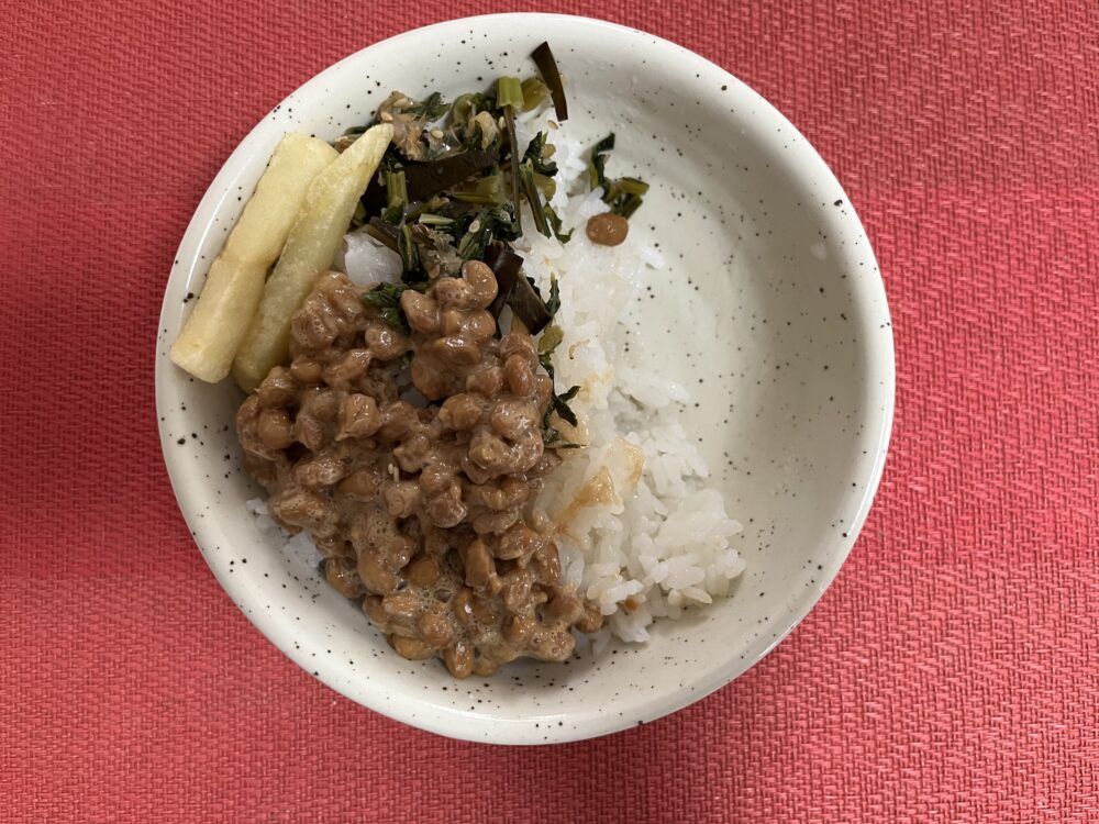 お皿の中に納豆ご飯と青菜のふりかけ